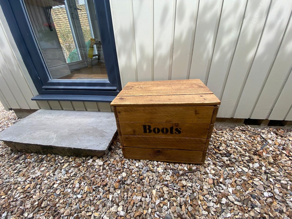 Private cabin entrance with an outdoor storage box on the gravel terrace