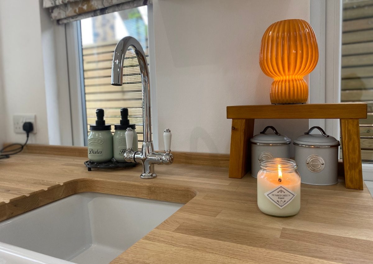 Kitchen sink, oak bench, candle and storage tins in the cabin
